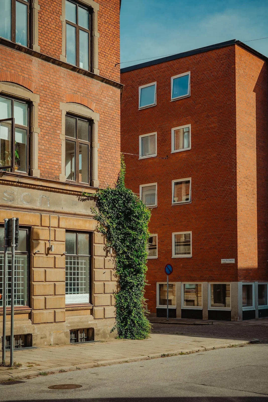 Red-brick buildings frame a quiet sunlit courtyard.